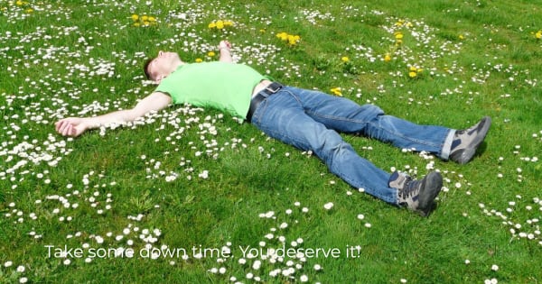 Picture of a person resting on a lawn with flowers.