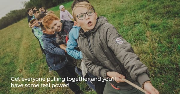 Image of kids playing tug of war to illustrate pulling together to accomplish things.