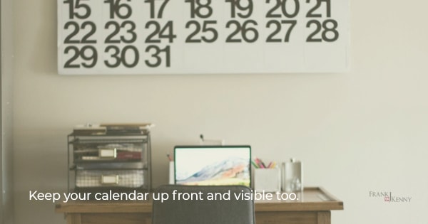 Image of a desk with a huge wall calendar.