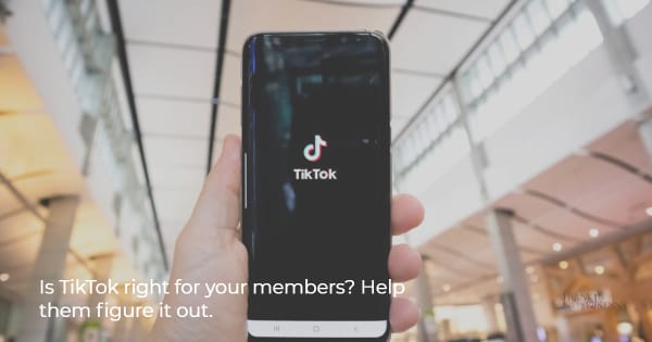 Image of a hand holding a phone with TikTok on the screen.