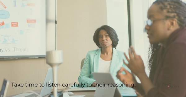 Image of a woman carefully listening to someone in a meeting.